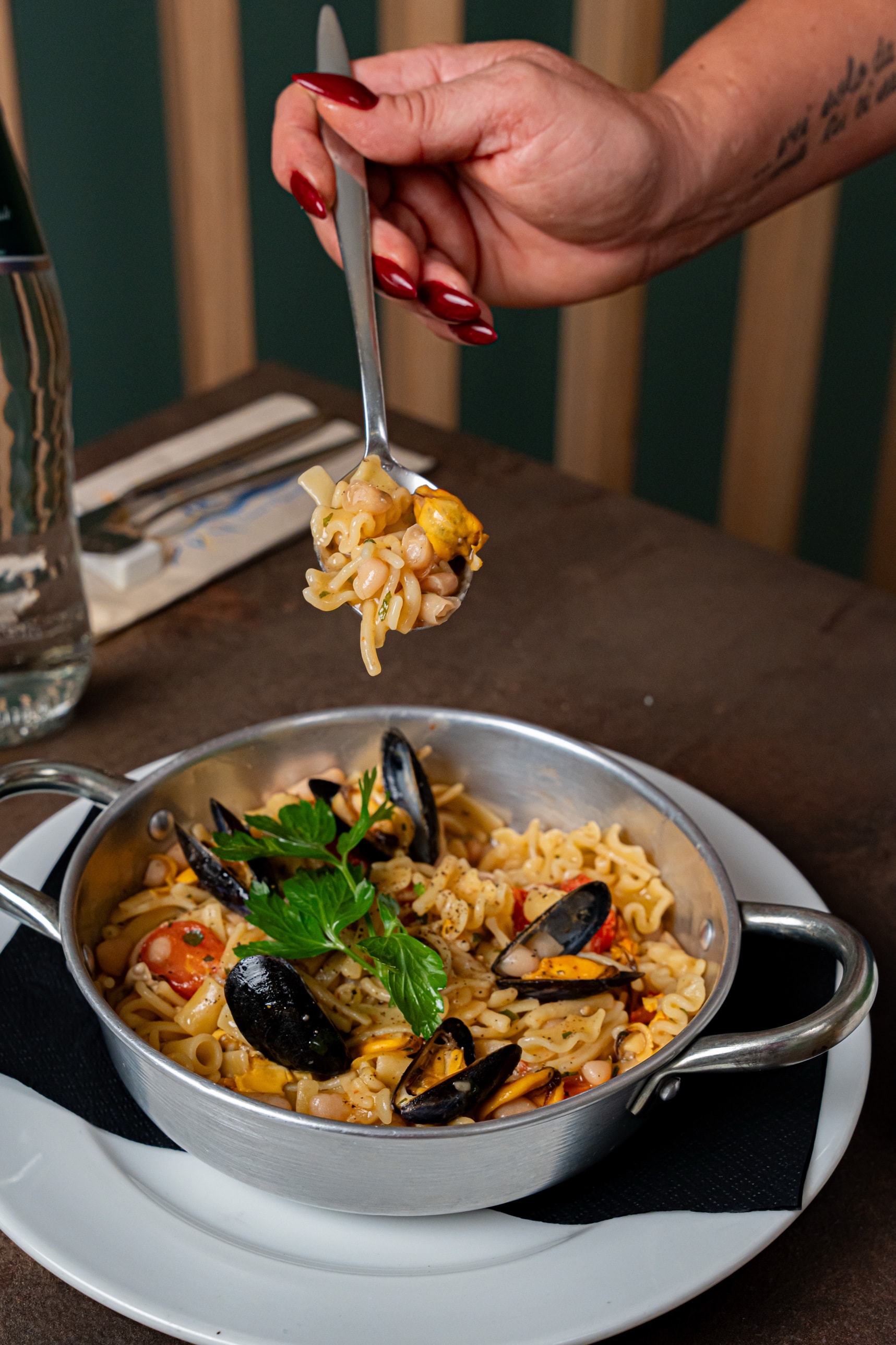 Pasta, fagioli e cozze in padellino, un cucchiaio sollevato